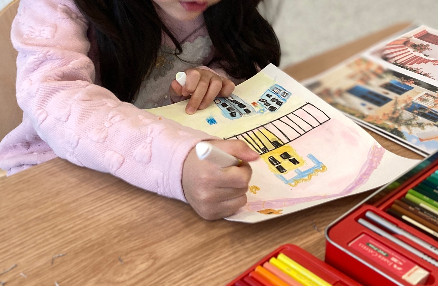 참고 사진을 보며 수채화로 풍경을 그리는 아이