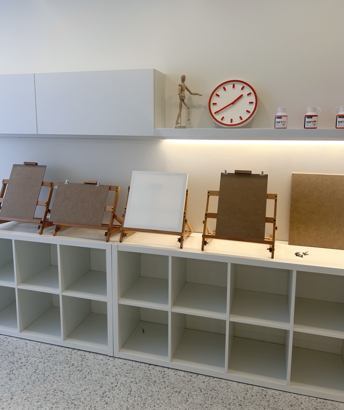 이젤이 가지런히 놓인 작업 공간과 시계, 인체 모형